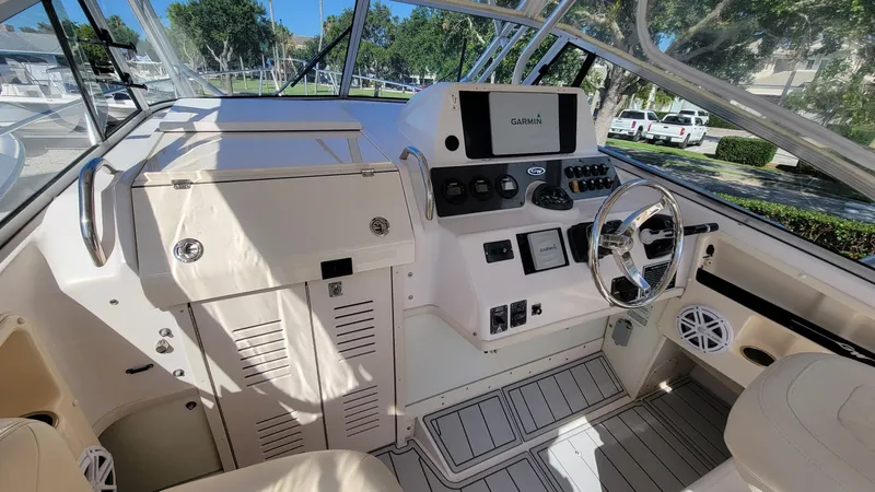 Slide: The Image of 2004 Grady-White Marlin 300 boat cockpit with steering wheel and navigation controls. - 10