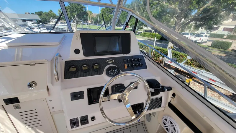 Slide: The Image of 2004 Grady-White Marlin 300 boat cockpit with steering wheel and control panel. - 14