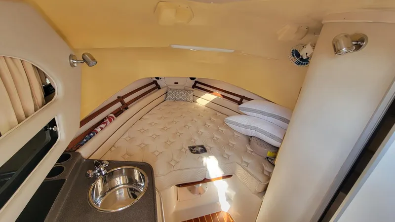 Slide: The Image of 2004 Grady-White Marlin 300 cabin interior with sink, bed, and cozy seating area. - 18