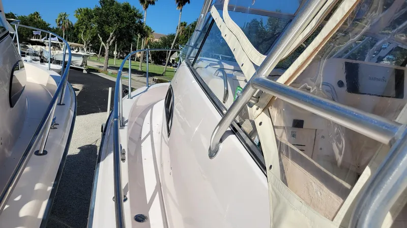 Slide: The Image of 2004 Grady-White Marlin 300 boat, side view with stainless steel railings, docked outdoors. - 22