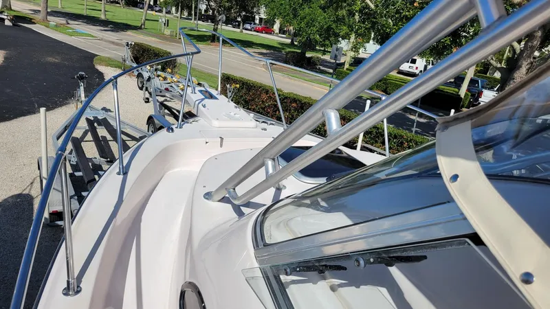 Slide: The Image of 2004 Grady-White Marlin 300 boat deck with railing and windshield, parked outdoors. - 23