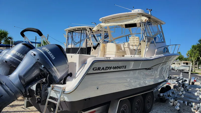 Slide: The Image of 2004 Grady-White Marlin 300 boat with Yamaha engines, docked under clear blue sky. - 3