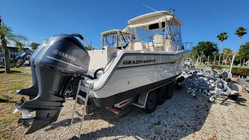 Slide: The Image of 2004 Grady-White Marlin 300 boat with Yamaha engines, parked on a gravel lot. - 4
