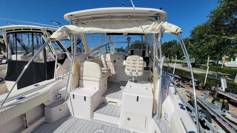 Slide: The Image of 2004 Grady-White Marlin 300 boat interior with seating and controls under a clear blue sky. - 6