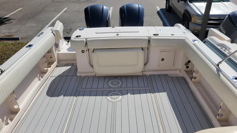 Slide: The Image of 2004 Grady-White Marlin 300 boat deck with twin engines, parked in a lot. - 8