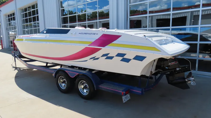 Slide: The Image of 1998 Eliminator 28 EAGLE XP speedboat on trailer, vibrant graphics, parked outside a garage. - 3