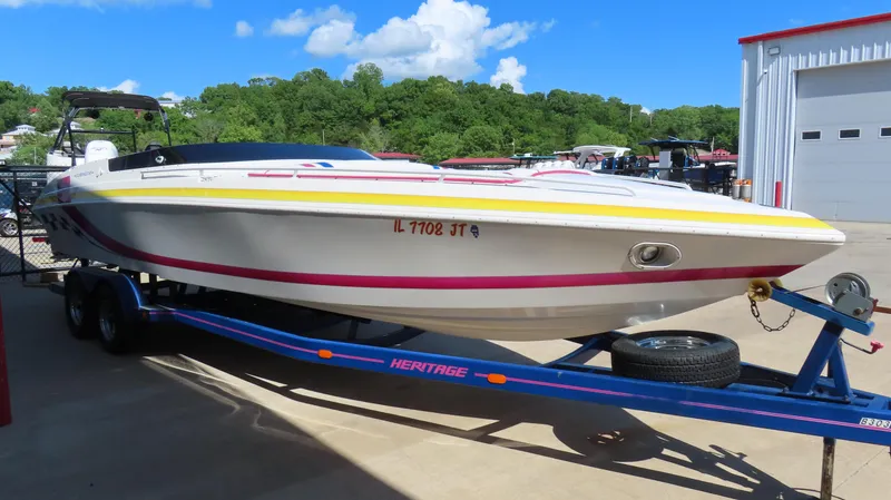 Slide: The Image of 1998 Eliminator 28 EAGLE XP boat on trailer, parked outdoors under blue sky. - 4