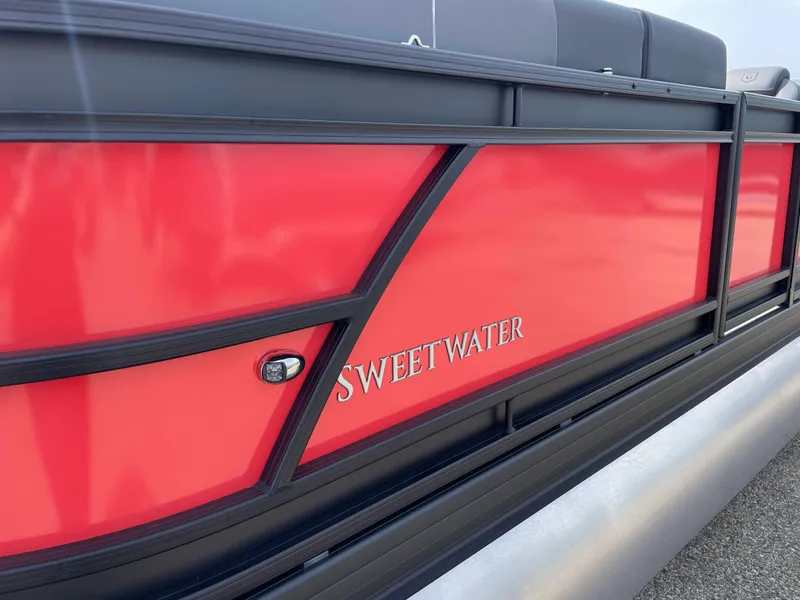 Slide: The Image of 2025 Godfrey SW2286SFLC Tritoon with sleek gray seating and red accents. - 18