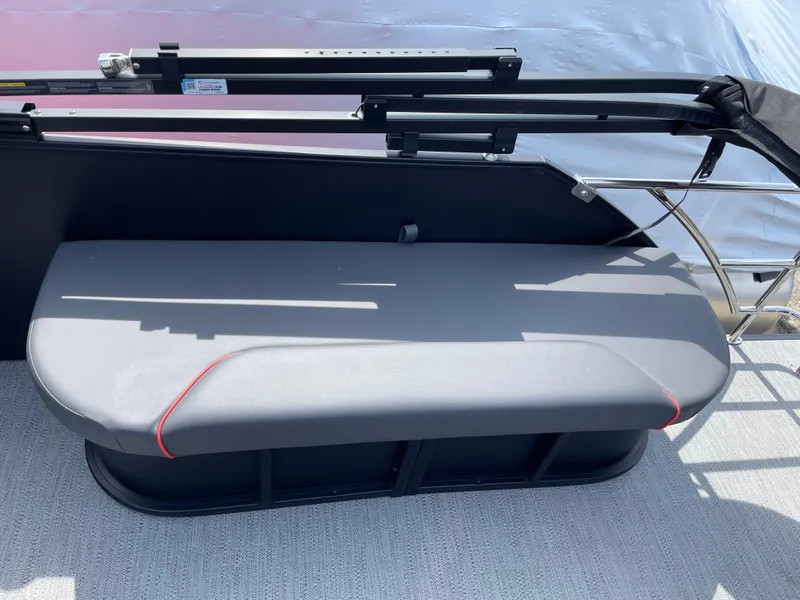 Slide: The Image of 2025 Godfrey SW2286SFLC Tritoon boat seat with sleek gray upholstery and red accents. - 21