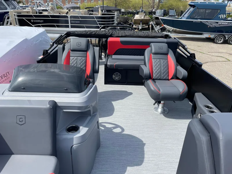 Slide: The Image of 2025 Godfrey SW2286SFLC Tritoon interior with modern seating and red accents. - 5