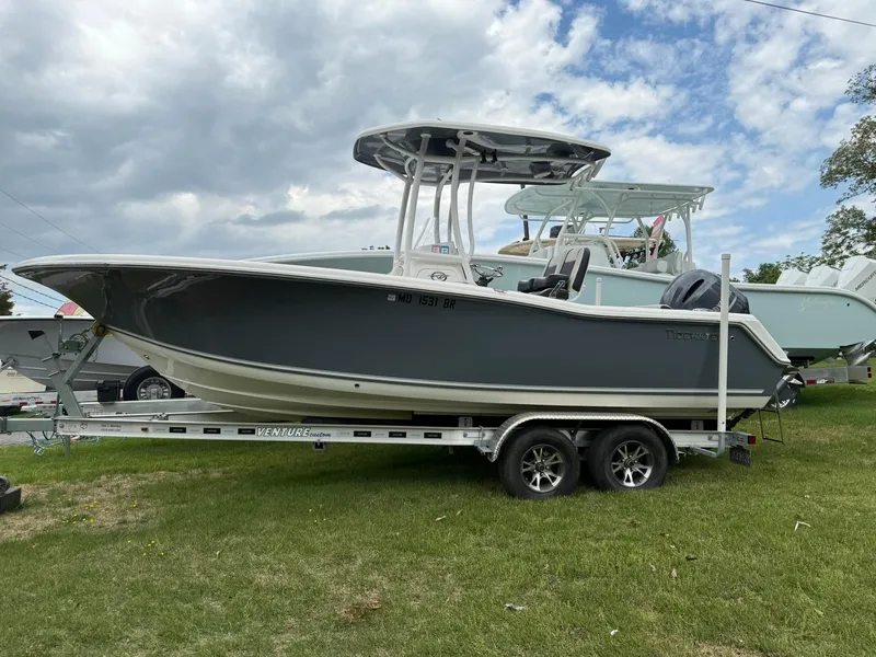 Slide: The Image of 2021 Tidewater 220 CC boat on trailer, parked on grass under cloudy sky. - 0