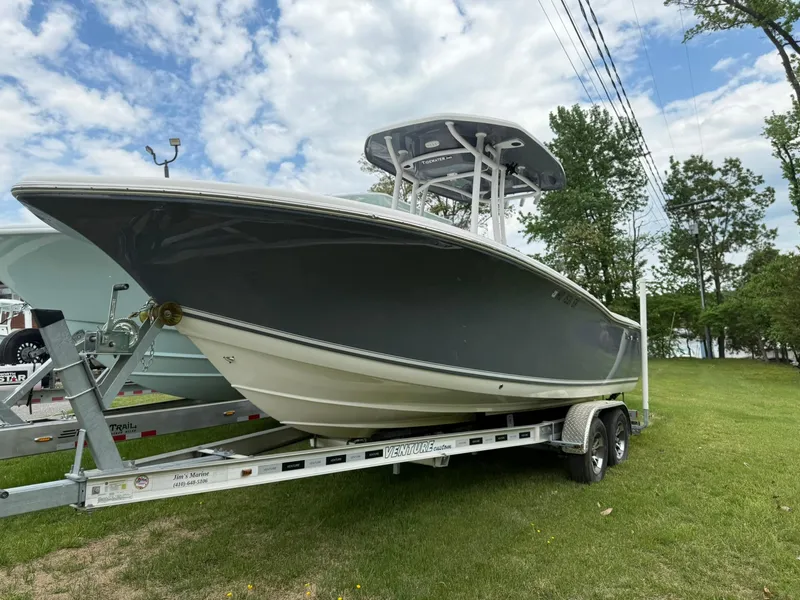 Slide: The Image of 2021 Tidewater 220 CC boat on trailer, parked on grass under cloudy sky. - 1
