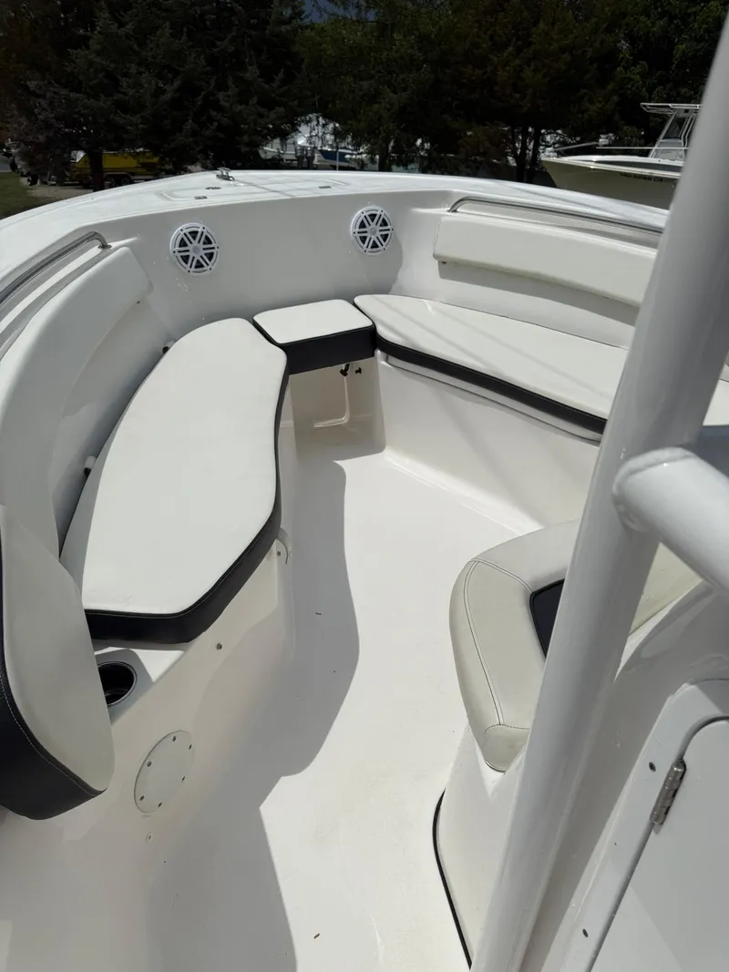 Slide: The Image of 2021 Tidewater 220 CC boat interior with white seating and speakers. - 10