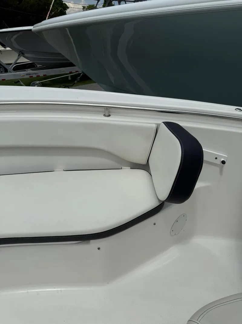 Slide: The Image of 2021 Tidewater 220 CC boat interior with white seating and black trim. - 12