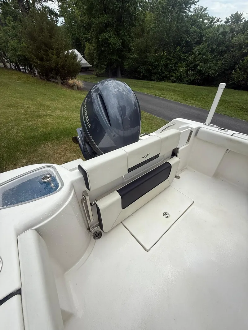 Slide: The Image of 2021 Tidewater 220 CC boat with outboard motor, parked on grass near a road. - 17
