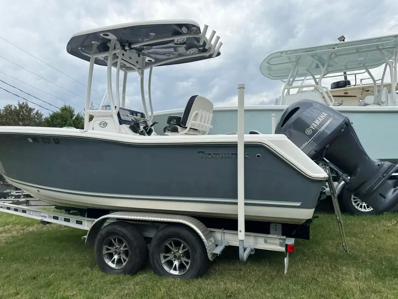 Slide: The Image of 2021 Tidewater 220 CC boat on trailer with Yamaha outboard motor, parked on grass. - 2