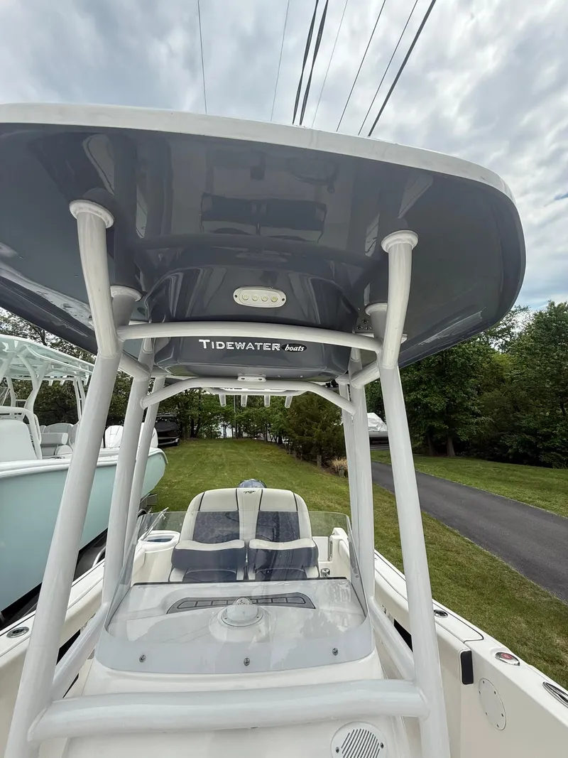 Slide: The Image of 2021 Tidewater 220 CC boat with T-top, parked on a grassy area. - 24