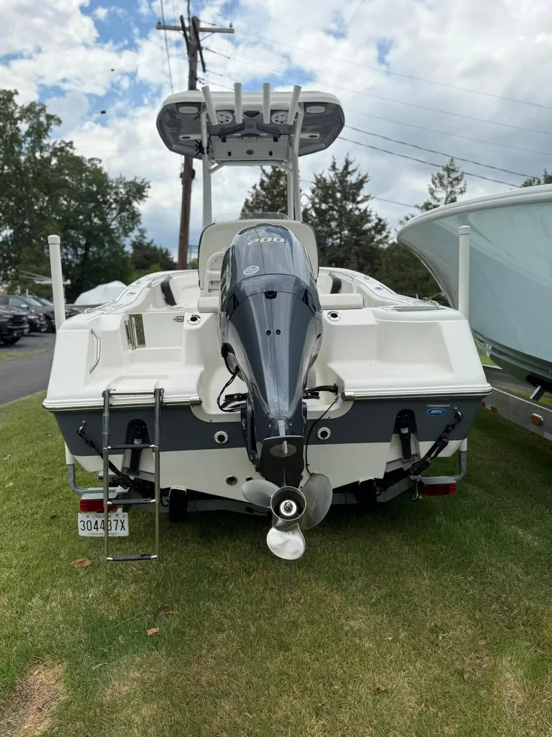 Slide: The Image of 2021 Tidewater 220 CC boat, rear view with outboard motor, parked on grass. - 26