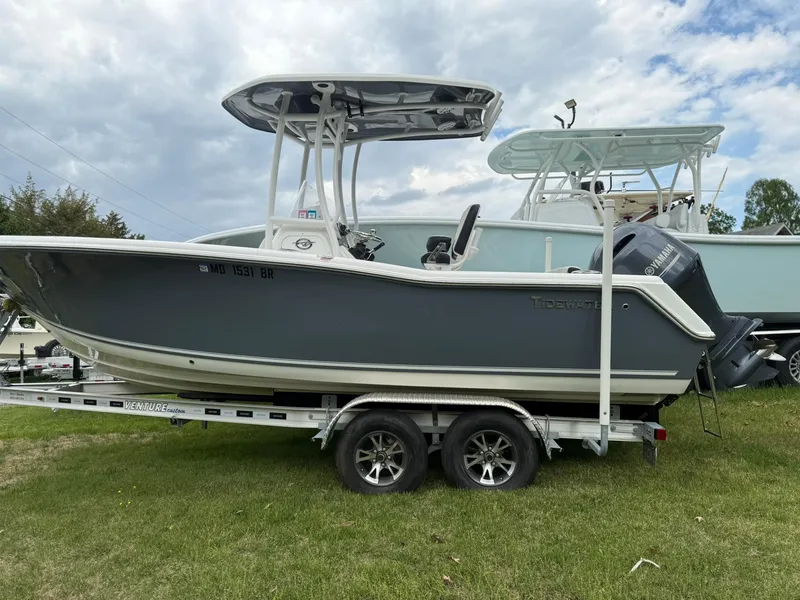 Slide: The Image of 2021 Tidewater 220 CC boat on trailer, parked on grass under cloudy sky. - 3