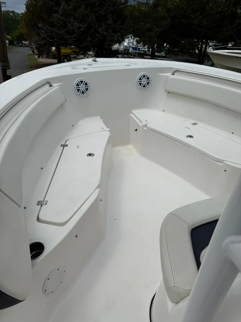 Slide: The Image of 2021 Tidewater 220 CC boat interior with white seating and storage compartments. - 8