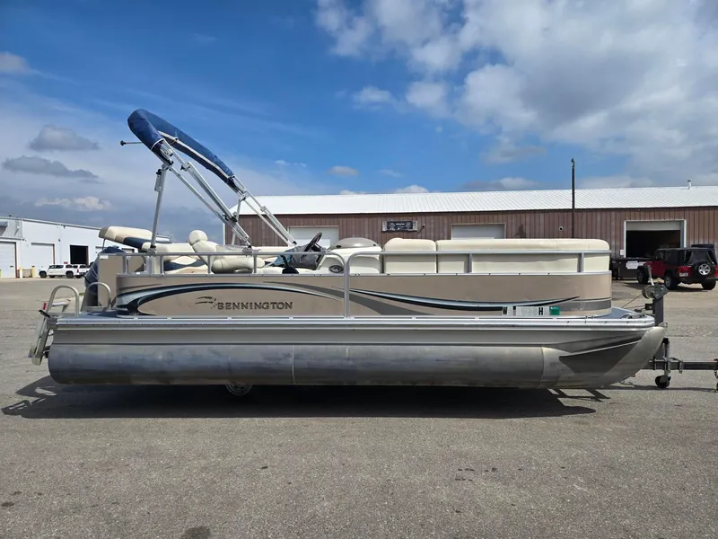 Slide: The Image of 2008 Bennington 2050 RL pontoon boat parked outdoors under a cloudy sky. - 4