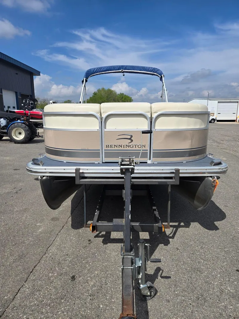 Slide: The Image of 2008 Bennington 2050 RL pontoon boat on trailer, parked outdoors under blue sky. - 6