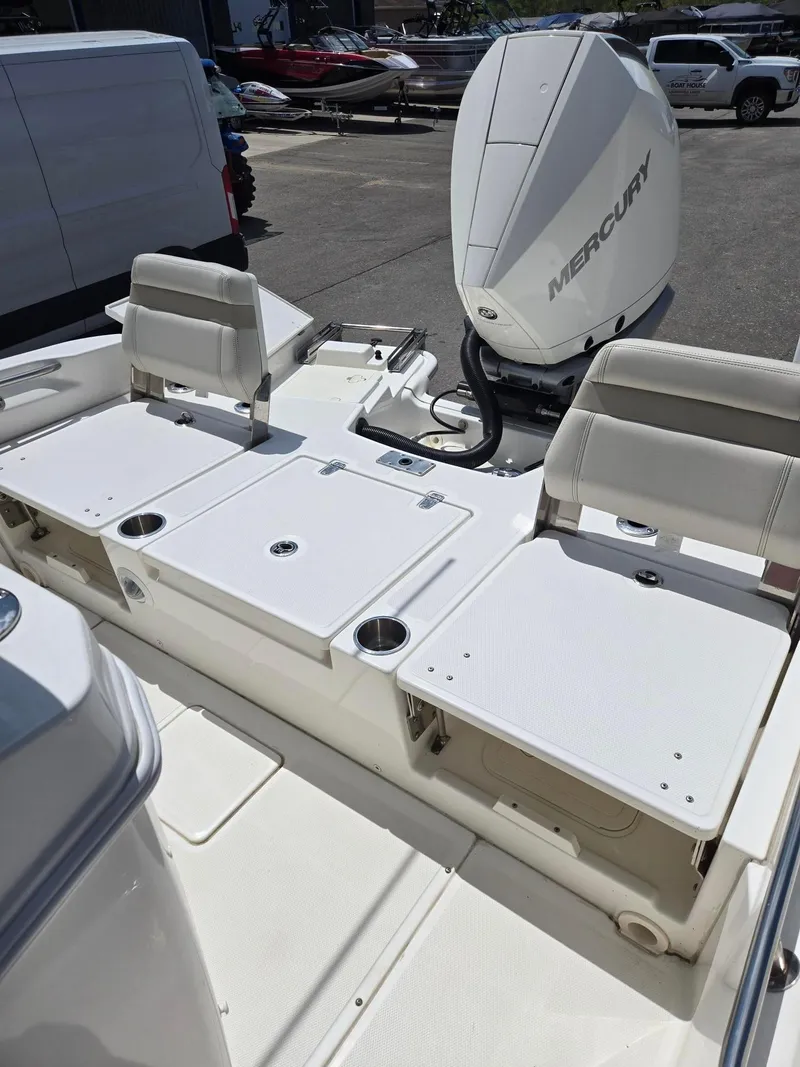 Slide: The Image of 2022 Boston Whaler Dauntless 250 boat interior with Mercury engine, featuring seating and storage. - 13