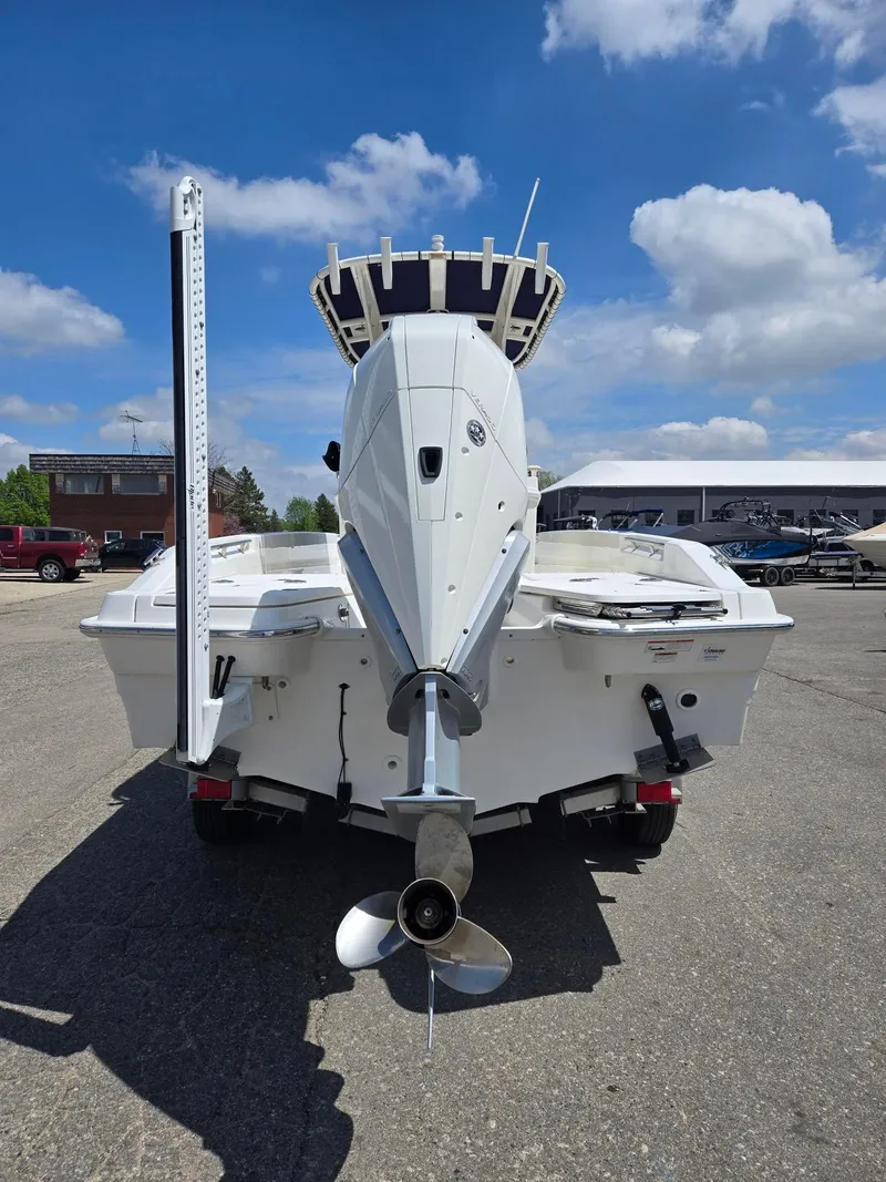 Slide: The Image of 2022 Boston Whaler Dauntless 250 boat, rear view with outboard motor, parked outdoors. - 14