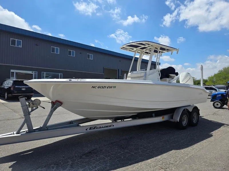 Slide: The Image of 2022 Boston Whaler Dauntless 250 boat on trailer, parked outdoors under blue sky. - 3