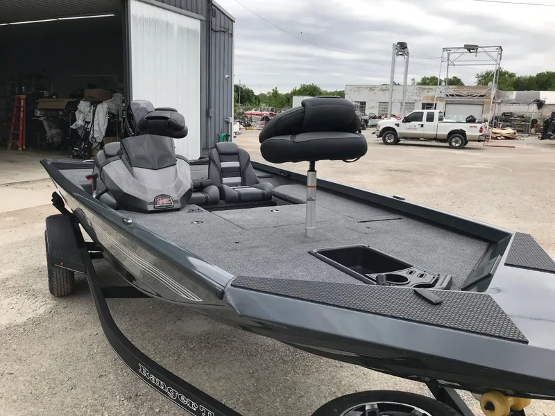 Slide: The Image of 2025 Ranger RT178 boat on trailer outside a large garage. - 5