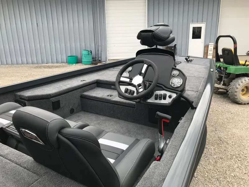 Slide: The Image of 2025 Ranger RT178 boat interior with seating and steering wheel, parked outdoors. - 7