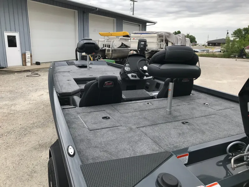 Slide: The Image of 2025 Ranger RT178 boat interior with steering wheel and seating, parked near a building. - 8