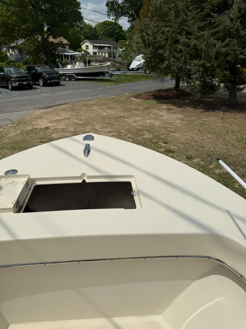 Slide: The Image of 2020 Jones Brothers 23 Cape Fisherman Lite Tackle boat on land, near trees and houses. - 10