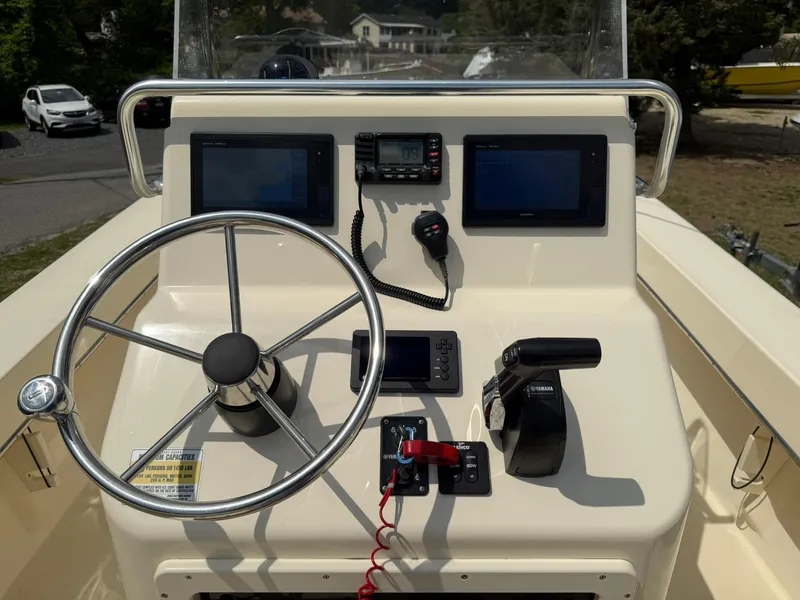 Slide: The Image of 2020 Jones Brothers 23 Cape Fisherman Lite Tackle boat dashboard with steering wheel and controls. - 2