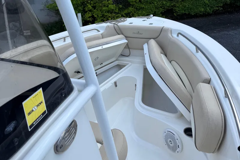 Slide: The Image of 2018 NauticStar 2102 Legacy boat interior with cushioned seating and storage compartments. - 6