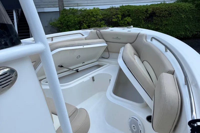 Slide: The Image of 2018 NauticStar 2102 Legacy boat interior with beige seating and storage compartments. - 7