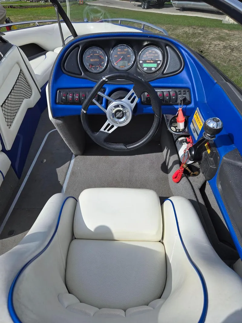 Slide: The Image of 2005 Malibu Response LXi boat interior with blue dashboard and white seating. - 12