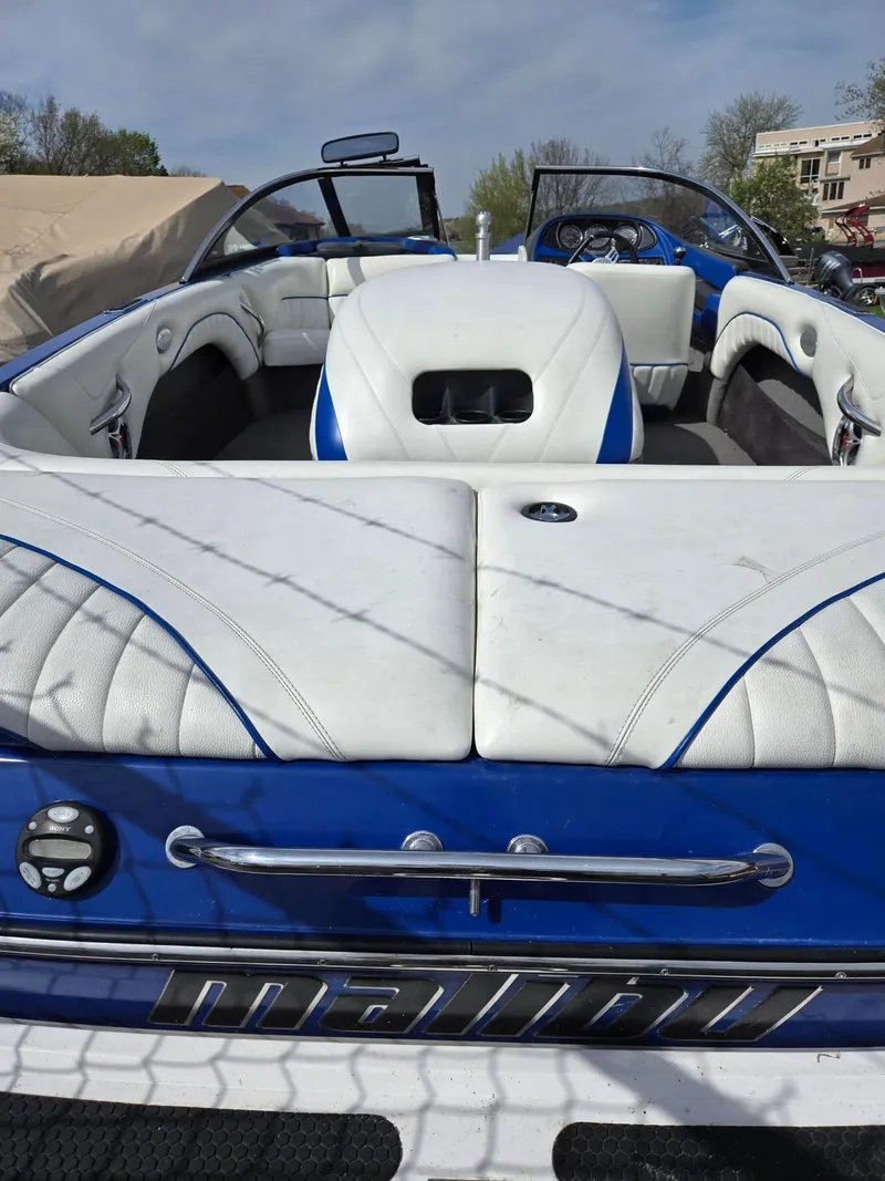 Slide: The Image of 2005 Malibu Response LXi boat with white and blue interior, parked outdoors. - 17