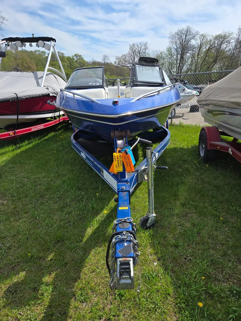Slide: The Image of 2005 Malibu Response LXi boat on trailer, parked on grass under a clear sky. - 3