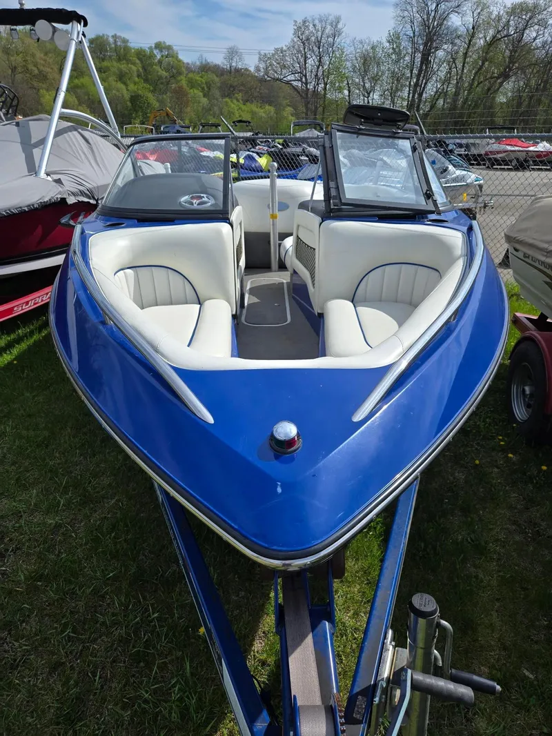 Slide: The Image of 2005 Malibu Response LXi boat with blue exterior and white interior, parked outdoors. - 5