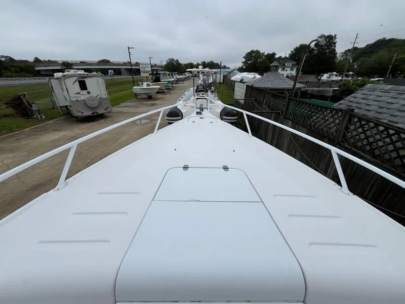 Slide: The Image of 2000 Donzi 35 ZF Daytona boat docked, viewed from the bow, with overcast sky. - 10