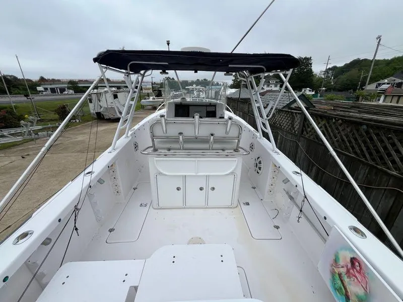 Slide: The Image of 2000 Donzi 35 ZF Daytona boat with spacious deck and canopy, docked outdoors. - 2