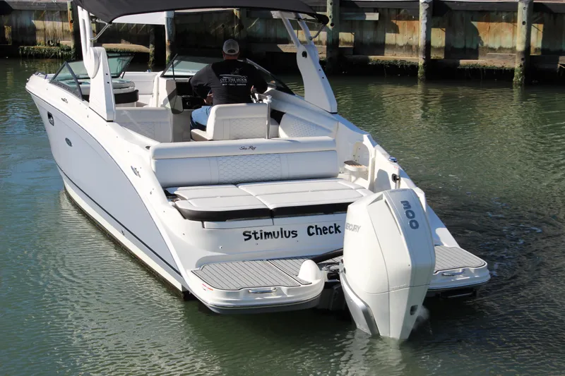 Slide: The Image of 2020 Sea Ray SDX 270 OB boat with outboard motor, docked in calm water. - 10