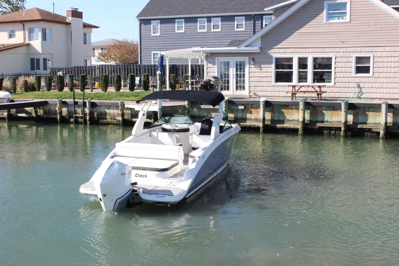 Slide: The Image of 2020 Sea Ray SDX 270 OB boat docked near waterfront homes. - 12