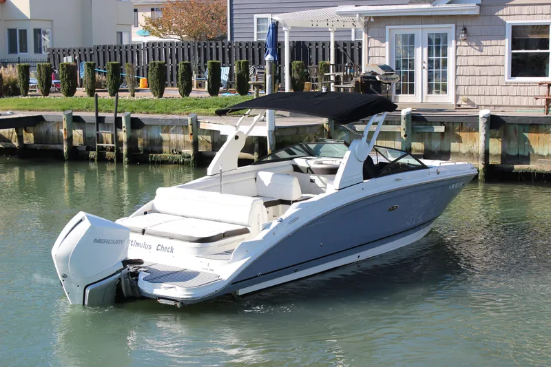Slide: The Image of 2020 Sea Ray SDX 270 OB boat docked in a serene waterfront setting. - 13