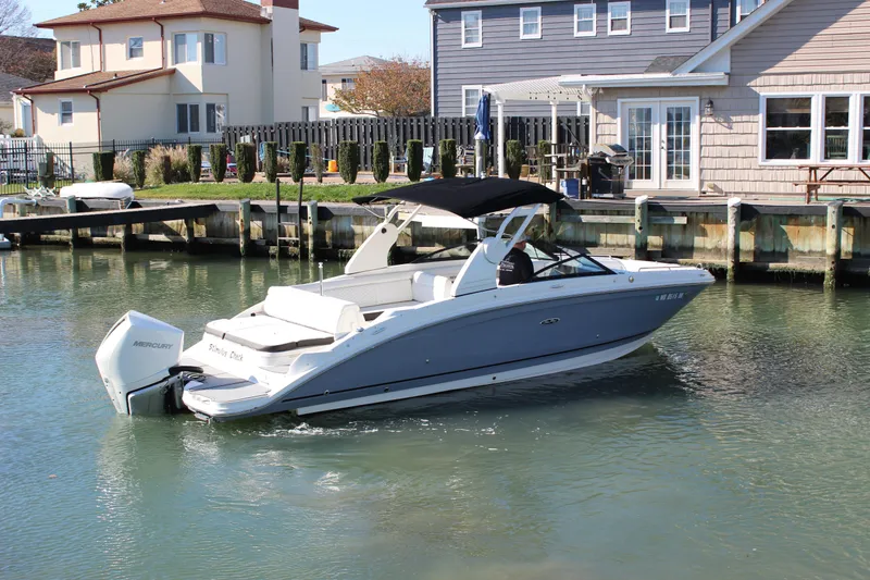 Slide: The Image of 2020 Sea Ray SDX 270 OB boat docked near waterfront homes. - 14