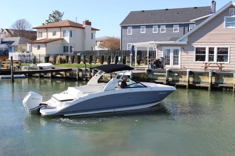 Slide: The Image of 2020 Sea Ray SDX 270 OB boat cruising near waterfront homes. - 15