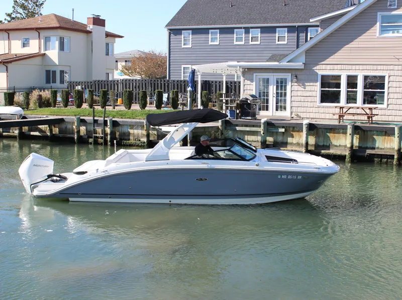Slide: The Image of 2020 Sea Ray SDX 270 OB boat cruising near waterfront homes. - 16