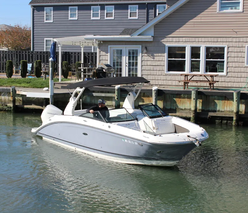 Slide: The Image of 2020 Sea Ray SDX 270 OB boat cruising near waterfront homes. - 17