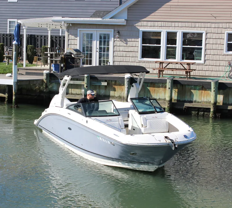Slide: The Image of 2020 Sea Ray SDX 270 OB boat docked near a waterfront house. - 18